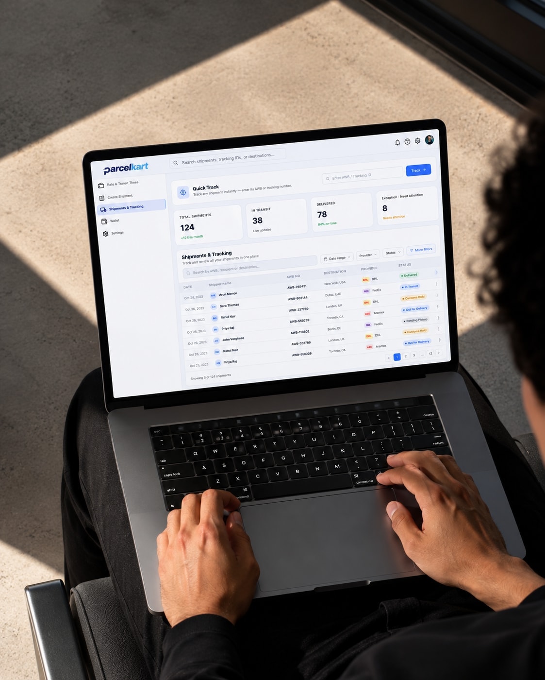 Hands typing on a laptop showing the ParcelKart operations dashboard