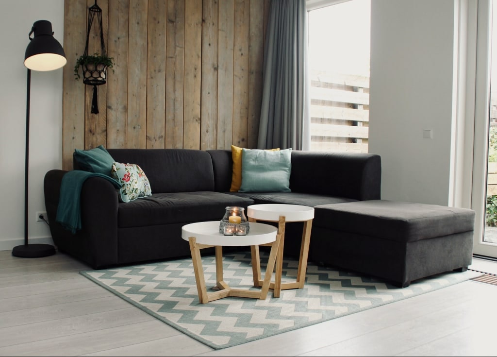 Delivered — a dark corner sofa and coffee tables in a living room