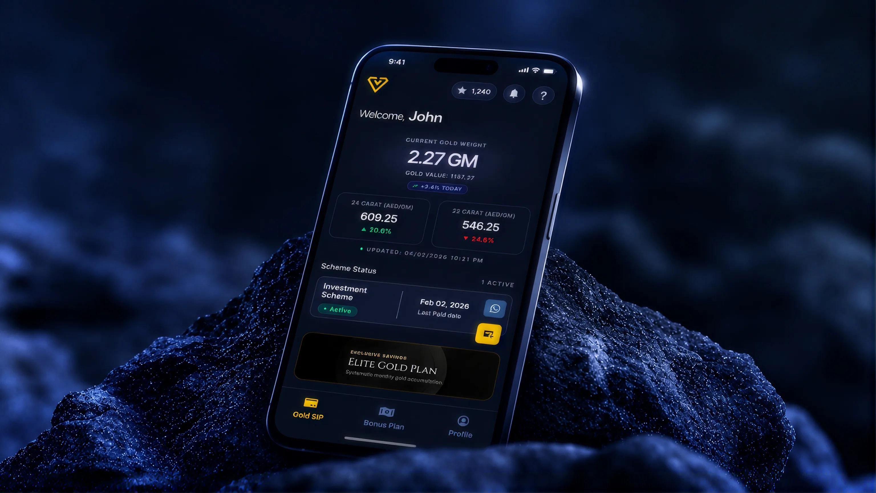 A phone resting on dark rock, showing the Venus Gold home screen: current gold weight 2.27 GM, today's 24 and 22 carat rates and the member's scheme status