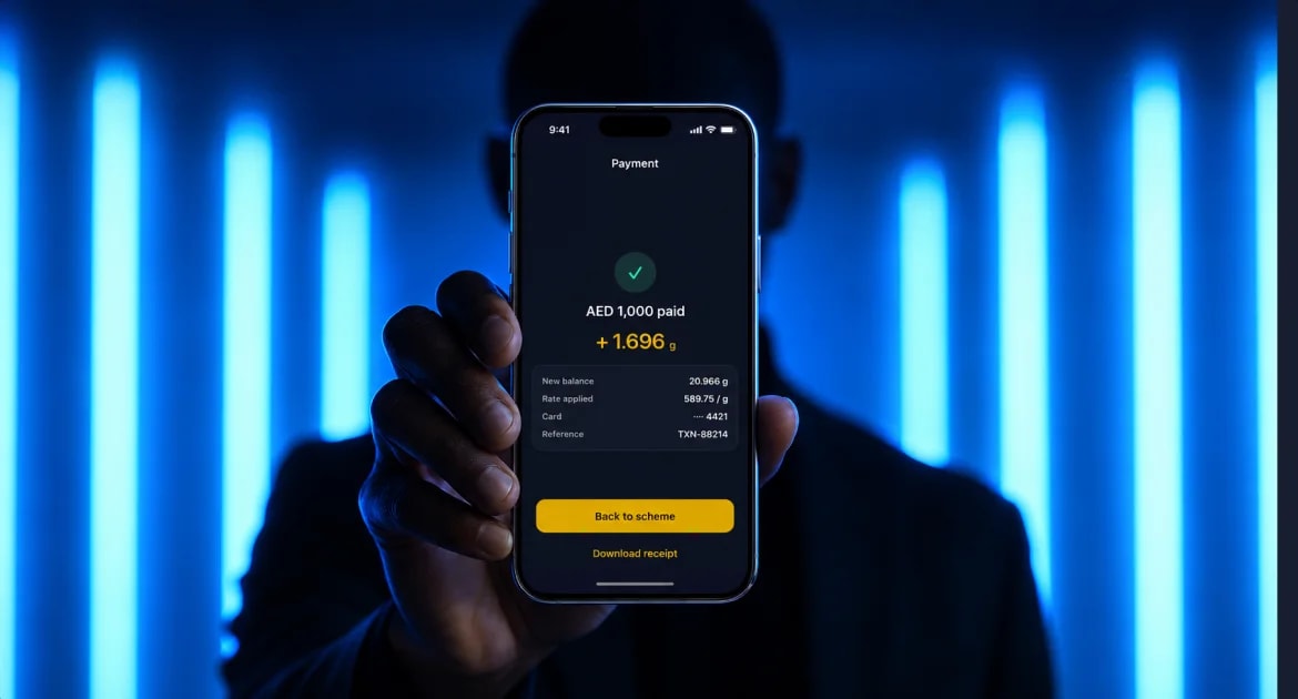 A person holding up a phone showing the payment success screen: AED 1,000 paid, +1.696 g, with the new balance, rate applied and reference